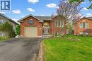 Red brick exterior featuring a single-car garage and an arched entryway - 29 Strong Court, Brantford, ON  - Outdoor With Facade 