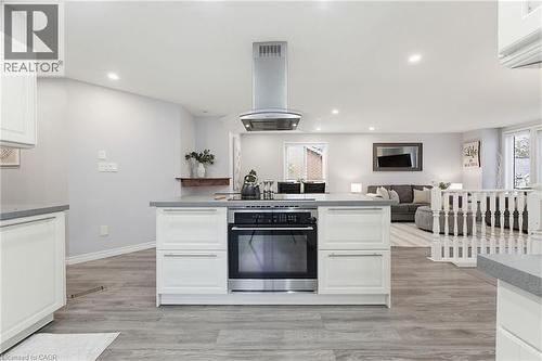 Kitchen island featuring a built-in stainless steel oven, cooktop, and overhead range hood - 29 Strong Court, Brantford, ON - Indoor Photo Showing Kitchen