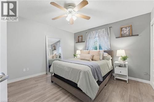 Bedroom featuring wood-finish flooring, a ceiling fan with integrated lighting, and light gray wall paint - 29 Strong Court, Brantford, ON - Indoor Photo Showing Bedroom