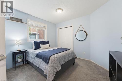 Carpeted room featuring a white window frame, light blue walls, and a built-in closet with bifold doors - 29 Strong Court, Brantford, ON - Indoor Photo Showing Bedroom