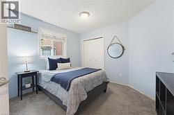 Carpeted room featuring a white window frame, light blue walls, and a built-in closet with bifold doors - 