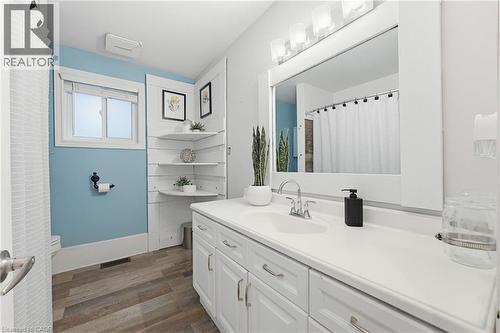 Bathroom featuring a single vanity with storage cabinetry, integrated sink, and an overhead light fixture - 29 Strong Court, Brantford, ON - Indoor Photo Showing Bathroom