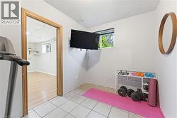 Versatile room featuring tile flooring, a wall-mounted display, and a window - 