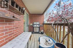 Covered outdoor deck with brick wall and wood-finish flooring - 