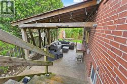 Covered patio with a concrete surface and exposed wood beam ceiling - 
