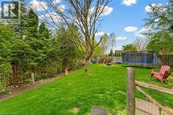 Expansive backyard featuring a manicured lawn, mature trees, and privacy fencing - 
