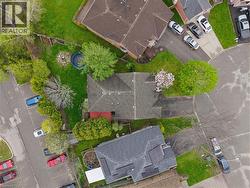 Aerial perspective showcasing a residential property with a shingled roof and a paved driveway - 