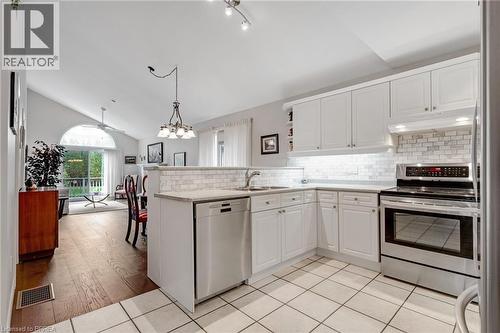 Kitchen featuring white cabinetry, stainless steel appliances, subway tile backsplash, and light-toned countertops - 422 Powerline Road Unit# 10, Brantford, ON - Indoor Photo Showing Kitchen
