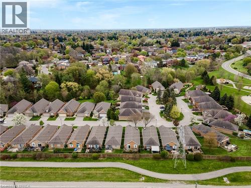 Aerial perspective showcasing residential properties with light-toned brick and siding exteriors, dark shingled roofs, and attached garages - 422 Powerline Road Unit# 10, Brantford, ON - Outdoor With View