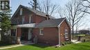 Brick exterior with a covered front porch featuring stone and brick columns - 3355 King Street E, Kitchener, ON  - Outdoor 