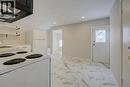 Kitchen area featuring white appliances, a range hood, open shelving, and patterned tile flooring - 3355 King Street E, Kitchener, ON  - Indoor Photo Showing Kitchen 
