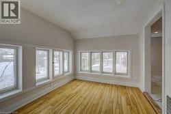 Room featuring wood-finish flooring, white baseboards, and light-colored walls - 