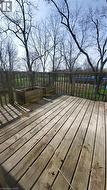 Wood deck with a slatted railing overlooking a treed landscape - 