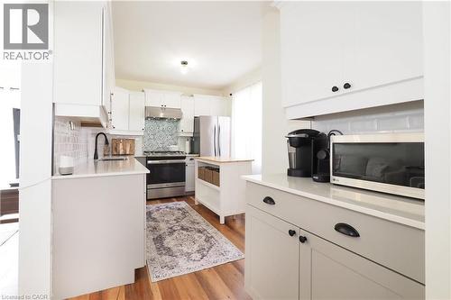 New kitchen built with a thoughtful efficient design, includes a pantry, gas stove, quartz countertops, stylish subway tiled backsplash, plenty of cabinetry and access do side door entryway. - 123 Samuel Street, Kitchener, ON - Indoor Photo Showing Kitchen With Stainless Steel Kitchen With Upgraded Kitchen