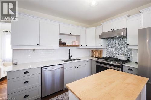 New kitchen built with a thoughtful efficient design, includes a pantry, gas stove, quartz countertops, stylish subway tiled backsplash, plenty of cabinetry and access do side door entryway. - 123 Samuel Street, Kitchener, ON - Indoor Photo Showing Kitchen With Stainless Steel Kitchen With Double Sink