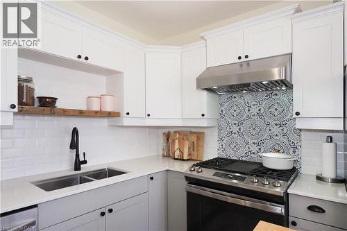 New kitchen built with a thoughtful efficient design, includes a pantry, gas stove, quartz countertops, stylish subway tiled backsplash, plenty of cabinetry and access do side door entryway. - 123 Samuel Street, Kitchener, ON - Indoor Photo Showing Kitchen With Double Sink