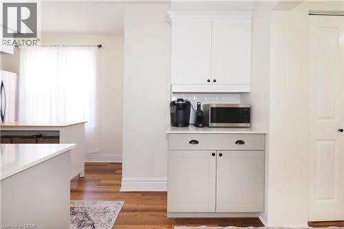 New kitchen built with a thoughtful efficient design, includes a pantry, gas stove, quartz countertops, stylish subway tiled backsplash, plenty of cabinetry and access do side door entryway. - 123 Samuel Street, Kitchener, ON - Indoor Photo Showing Kitchen