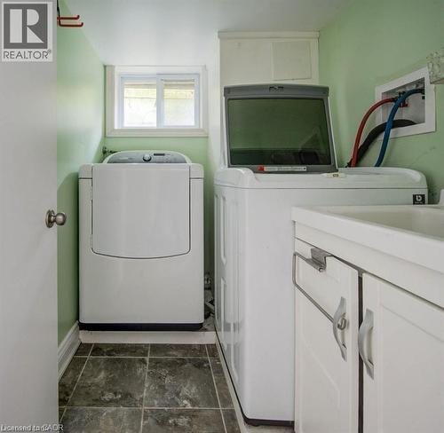 Dedicated laundry area featuring a utility sink with white cabinetry, tile flooring, and a window for natural light - 33 Sixth Avenue, Kitchener, ON - Indoor Photo Showing Laundry Room