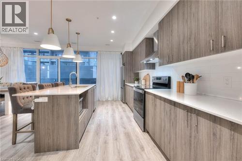 Kitchen with a breakfast bar, stainless steel appliances, modern cabinets, a large island, and light wood-style floors - 50 Grand Avenue S Unit# 602, Cambridge, ON - Indoor Photo Showing Kitchen With Upgraded Kitchen