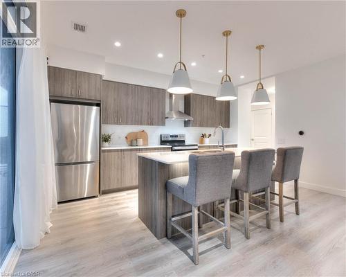 Kitchen featuring stainless steel appliances, modern cabinets, decorative light fixtures, and a center island with sink - 50 Grand Avenue S Unit# 602, Cambridge, ON - Indoor Photo Showing Kitchen With Upgraded Kitchen