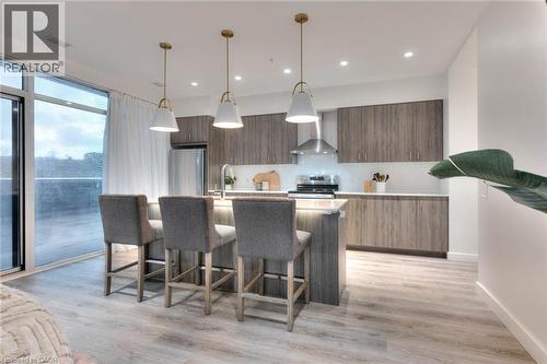 Kitchen featuring modern cabinets, a breakfast bar, an island with sink, and pendant lighting - 50 Grand Avenue S Unit# 602, Cambridge, ON - Indoor