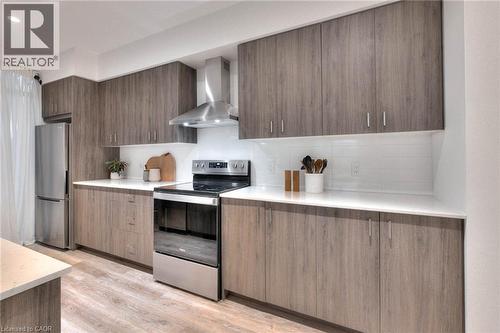 Kitchen with modern cabinets, stainless steel appliances, tasteful backsplash, light wood-style flooring, and light stone countertops - 50 Grand Avenue S Unit# 602, Cambridge, ON - Indoor Photo Showing Kitchen