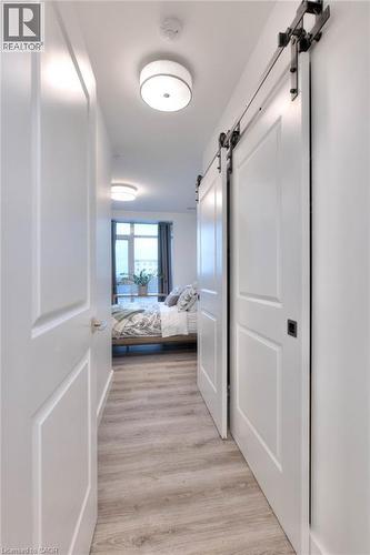 Hallway with a barn door and light wood-style floors - 50 Grand Avenue S Unit# 602, Cambridge, ON - Indoor