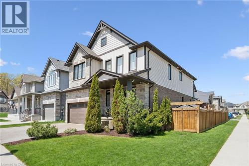 Modern architectural design featuring varied siding, stone accents, and a covered front entry - 72 Elmbank Trail, Kitchener, ON - Outdoor