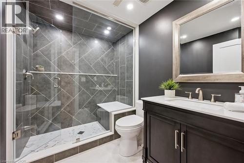 Contemporary bathroom featuring a dark vanity with a white countertop and rectangular sink - 72 Elmbank Trail, Kitchener, ON - Indoor Photo Showing Bathroom
