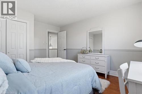 Bedroom featuring wood-finish flooring, white bifold closet doors, and two-tone wall paneling - 19 Forestview Drive, Cambridge, ON - Indoor Photo Showing Bedroom