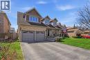 Stone and shingle facade featuring multiple dormers, a covered front porch, and a double garage with decorative glass inserts - 19 Forestview Drive, Cambridge, ON  - Outdoor With Facade 