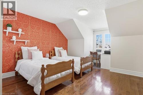 Attic-level room featuring a patterned accent wall, hardwood flooring, and a built-in window nook - 19 Forestview Drive, Cambridge, ON - Indoor Photo Showing Bedroom