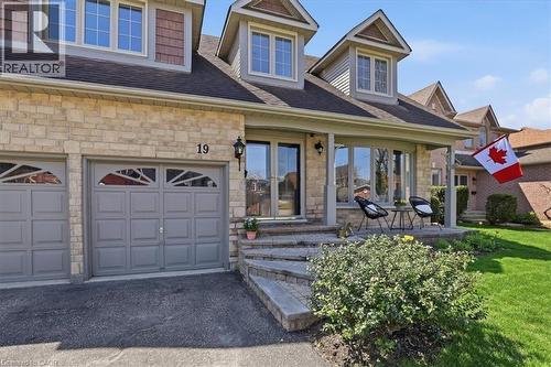 Stone and siding exterior with multiple dormer windows and an integrated two-car garage - 19 Forestview Drive, Cambridge, ON - Outdoor
