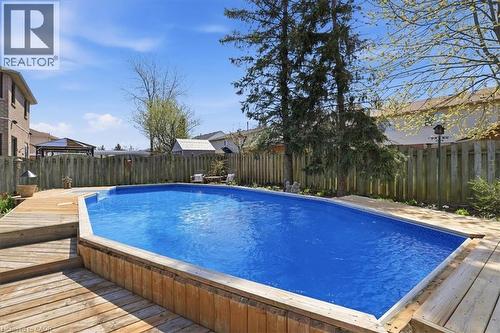 In-ground swimming pool featuring a bright blue liner and surrounding wood deck - 19 Forestview Drive, Cambridge, ON - Outdoor With Above Ground Pool With Backyard