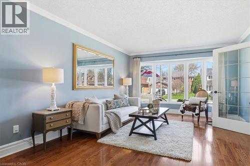 Living area featuring hardwood flooring, a multi-pane bay window, crown molding, and French doors - 19 Forestview Drive, Cambridge, ON - Indoor Photo Showing Living Room