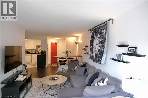 Open-concept living space featuring dark wood-finish flooring - 175 Hunter Street E Unit# 301, Hamilton, ON - Indoor Photo Showing Living Room
