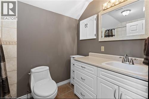 Bathroom featuring a white vanity with extensive storage, a large framed mirror, a single-handle faucet, a toilet, and neutral wall paint - 204 Beach Boulevard, Hamilton, ON - Indoor Photo Showing Bathroom