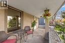 Covered porch with concrete flooring, a stucco exterior, and a prominent large window - 204 Beach Boulevard, Hamilton, ON  - Outdoor With Exterior 