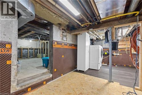 Utility area with wood-finish flooring, exposed ceiling joists, and a washer and dryer set - 204 Beach Boulevard, Hamilton, ON - Indoor Photo Showing Basement
