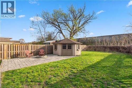 Expansive backyard featuring a central lawn, a distinct paver patio, and a built-in fire pit - 204 Beach Boulevard, Hamilton, ON - Outdoor