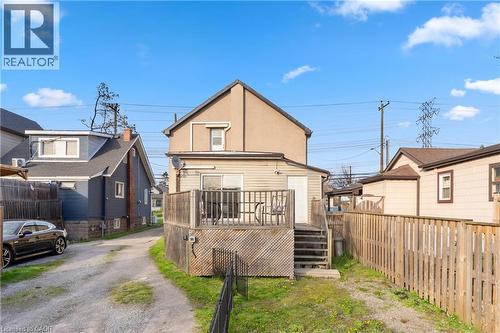 Rear exterior featuring a wood deck with railing, sliding glass door access, and a wooden privacy fence - 204 Beach Boulevard, Hamilton, ON - Outdoor