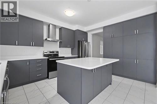 Kitchen featuring an expansive island, grey flat-panel cabinetry, stainless steel appliances, a range hood, and light-toned tile flooring - 123 Rea Drive, Fergus, ON - Indoor Photo Showing Kitchen With Upgraded Kitchen