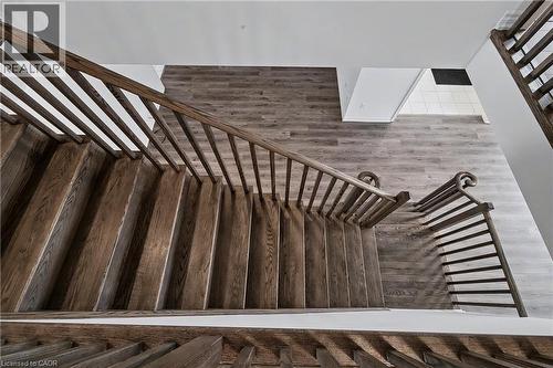 Hardwood staircase featuring dark wood treads and banisters with decorative newel posts - 123 Rea Drive, Fergus, ON - Indoor