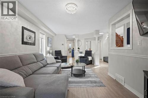 Bright living area featuring light wood-finish flooring, recessed lighting, and a decorative crystal chandelier - 30 Heatherwood Place, Kitchener, ON - Indoor Photo Showing Living Room
