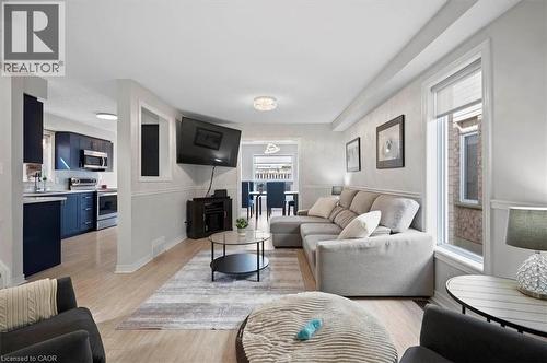 Open-concept living space featuring light wood-finish flooring, white baseboards, and chair rail molding - 30 Heatherwood Place, Kitchener, ON - Indoor Photo Showing Living Room
