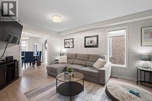 Bright living area featuring light-toned wood-finish flooring and crown molding - 30 Heatherwood Place, Kitchener, ON - Indoor Photo Showing Living Room
