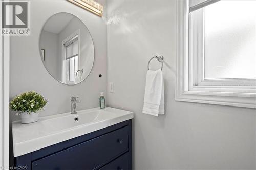 Modern vanity with a rectangular integrated sink, chrome faucet, and navy blue cabinetry - 30 Heatherwood Place, Kitchener, ON - Indoor Photo Showing Bathroom