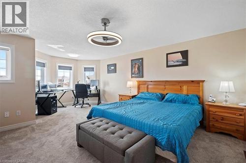 Spacious bedroom featuring plush gray carpeting, a multi-window bay area, and a modern ceiling fan with integrated lighting - 30 Heatherwood Place, Kitchener, ON - Indoor Photo Showing Bedroom