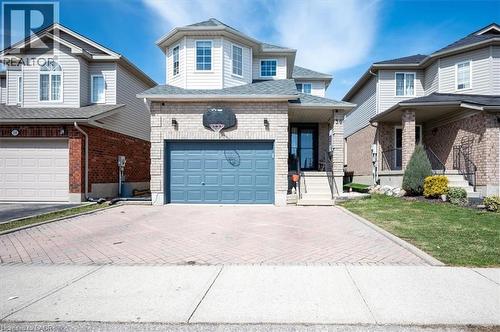 Two-story residence featuring light brick and light siding, an integrated single-car garage, and a bay window element - 30 Heatherwood Place, Kitchener, ON - Outdoor With Facade
