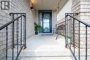 Inviting front porch featuring a dark grey storm door, complementary exterior sconce lighting, and durable brick facade accents - 30 Heatherwood Place, Kitchener, ON  - Outdoor With Exterior 